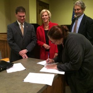 Noah Simon, Lexington’s new city manager, watches with Mayor Mimi Elrod and City Attorney Larry Mann as Clerk of Council Brenda Doyle signs his contract documents. Council unanimously appointed Simon Thursday night to succeed Jon Ellestad, who is retiring.  