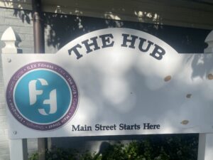 The sign for the HUB building, with Flex Fitness logo and large blank spaces. The bottom reads "Main Street Starts Here"