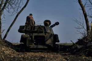 An artillery vehicle with someone sitting on the back.