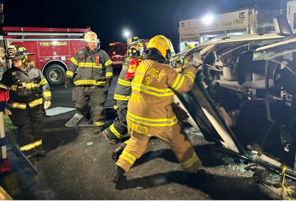 Firefighters flipping a car in a crash site. 