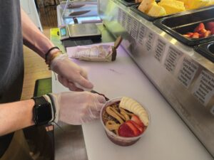 Close up image of an acai bowl being assembled.