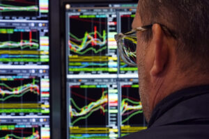 Over the shoulder image of stock trend lines on a monitor.