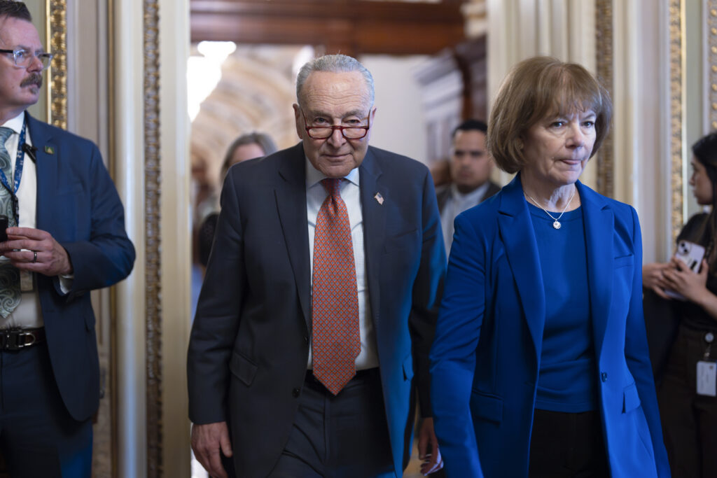 Chuck Schumer walks through the hall of the Capitol building.