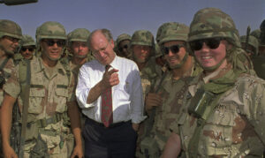 Photo of Defense Secretary Dick Cheney poses with U.S. Army troops.