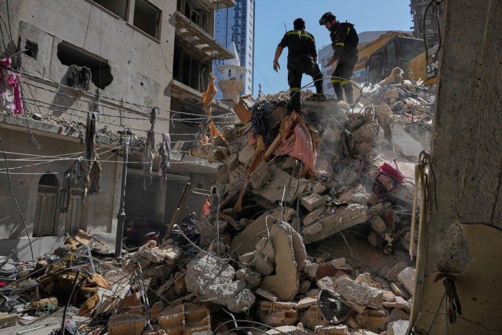 Lebanese civil defense workers inspect the rubble at the site of a building destroyed in an Israeli airstrike a day earlier in Beirut, Lebanon. 